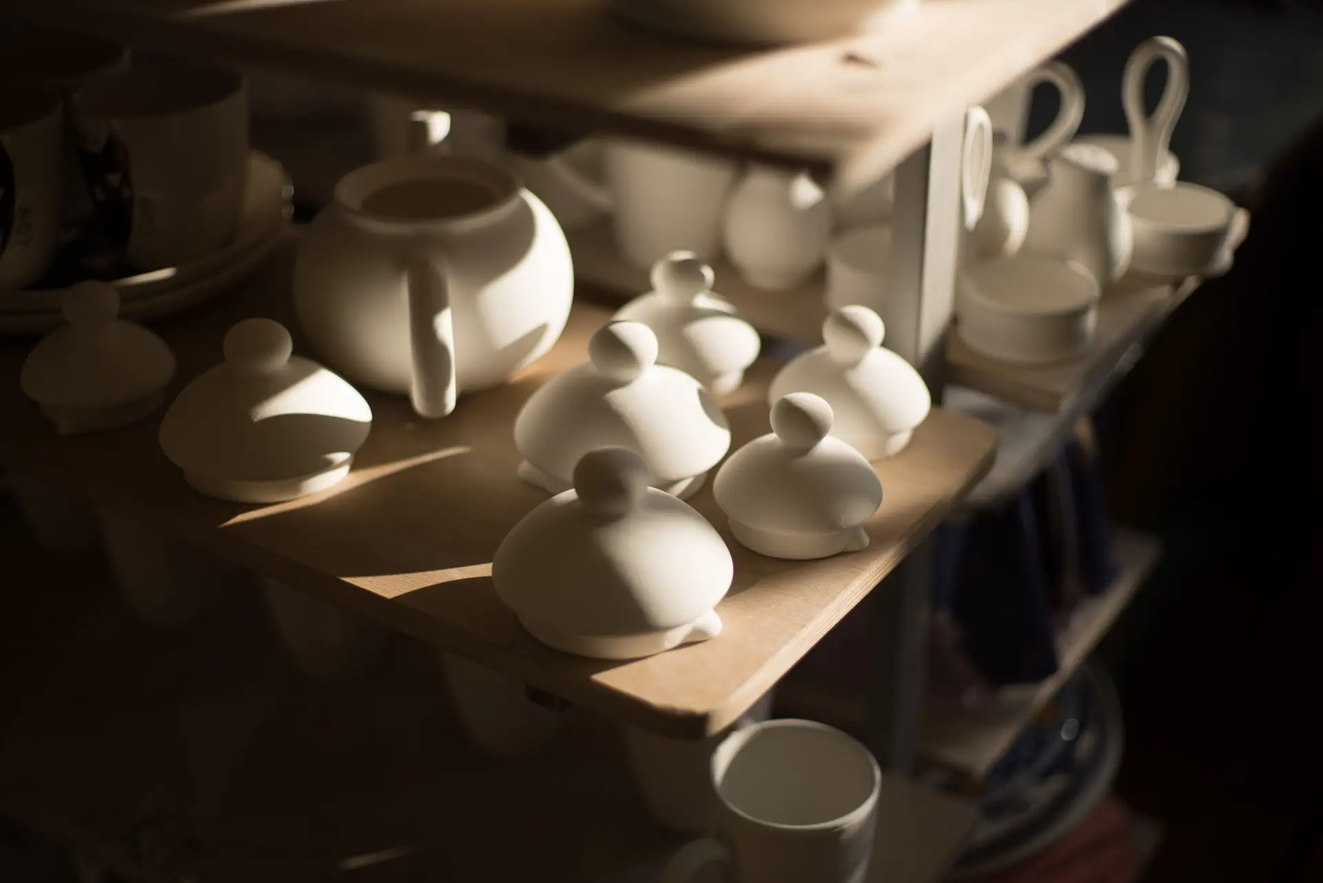 Artisan ceramic teapots on a wooden shelf